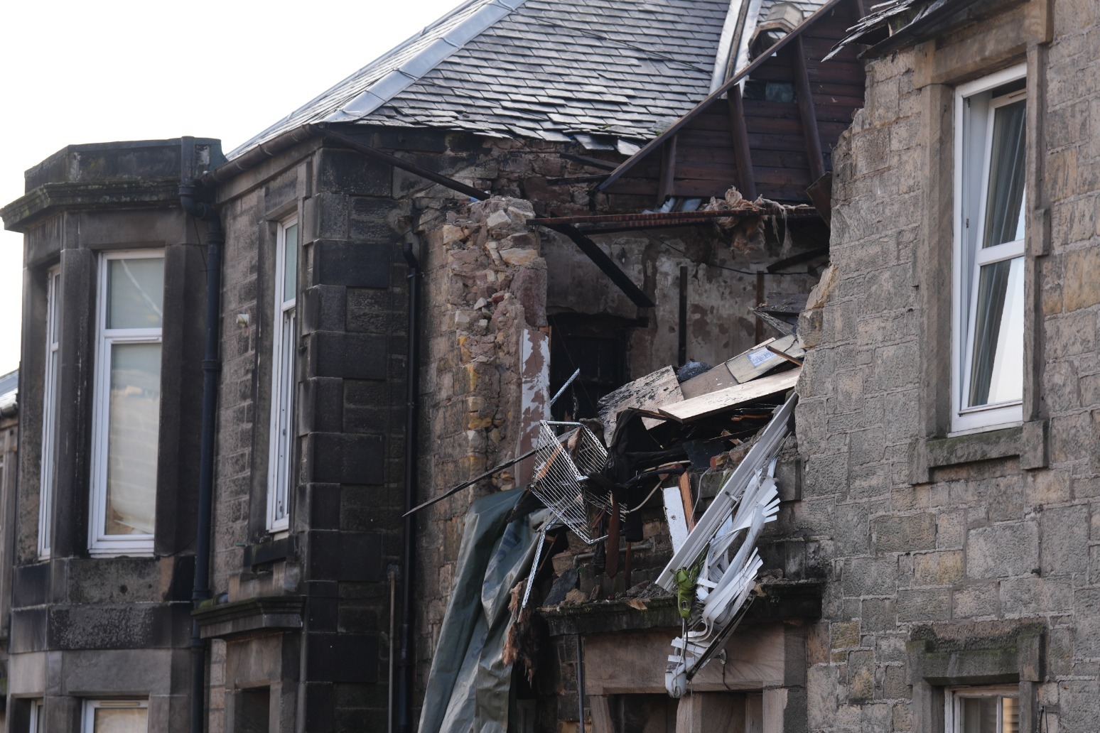 Police inquiries ongoing after man killed and three injured in flats blast 